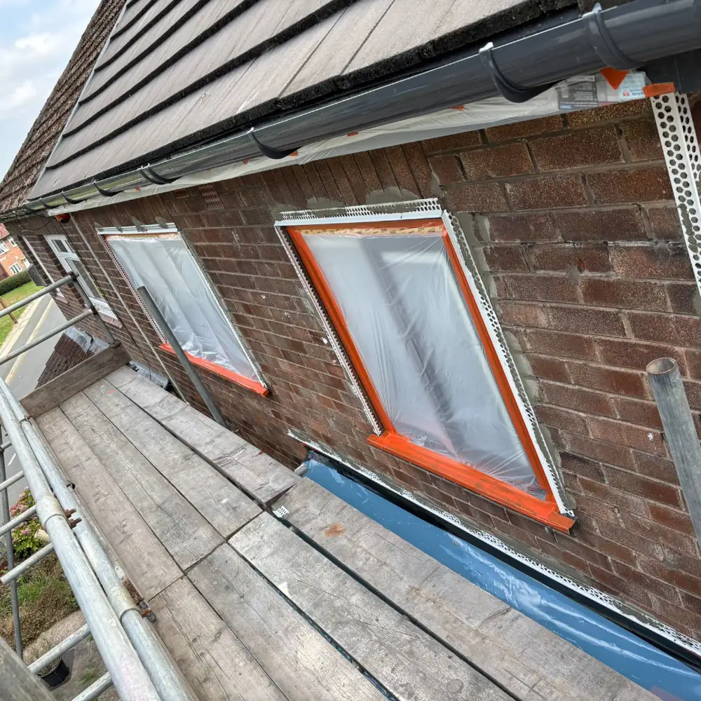 Masking up windows and doors to protect them before spraying external render